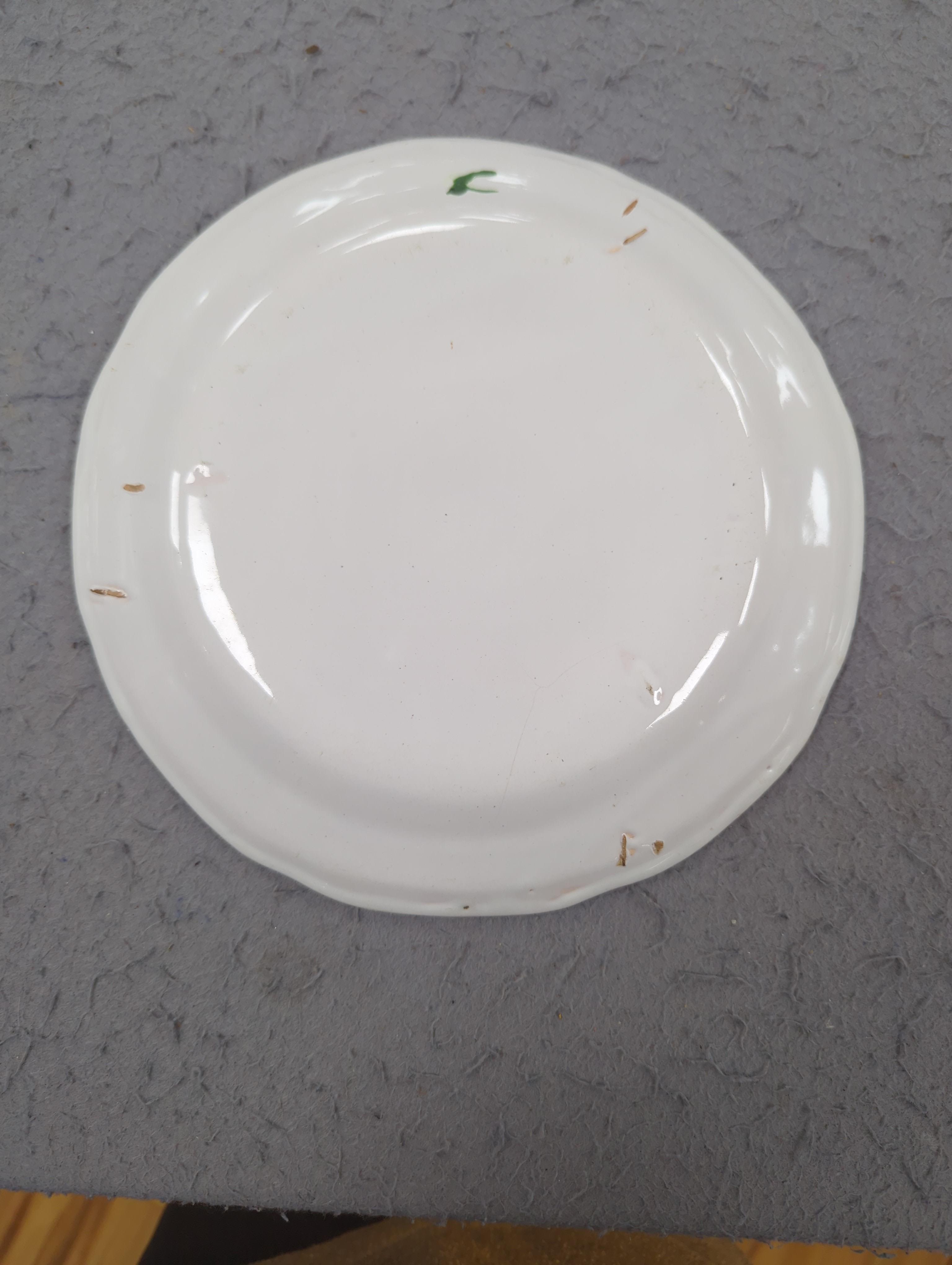 An 18th century Delft plate and three 19th century faience plates, largest 26cm diameter (4)